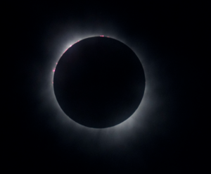 Total solar eclipse image shows corona and sunbursts.